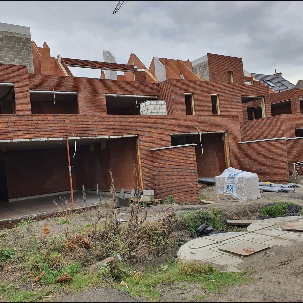 Rijwoningen in rode gevelsteen tijdens ruwbouw